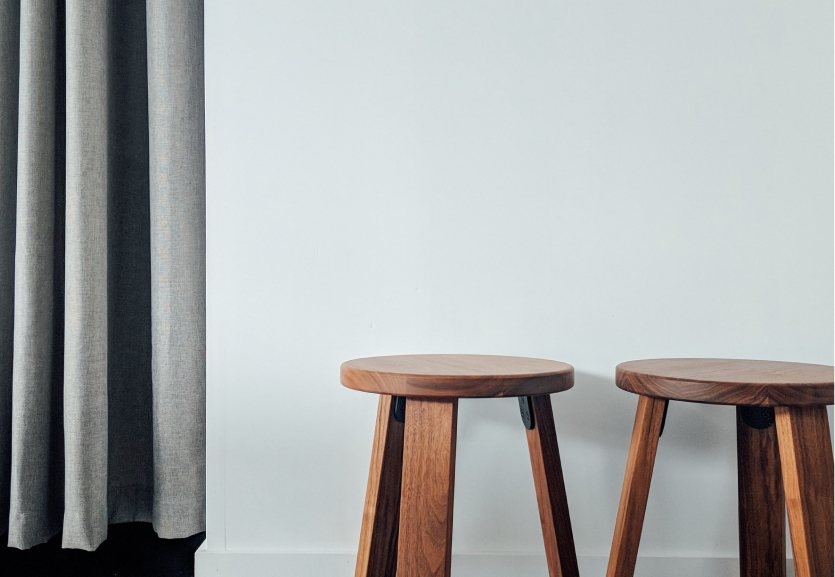 Two wooden stools by a window